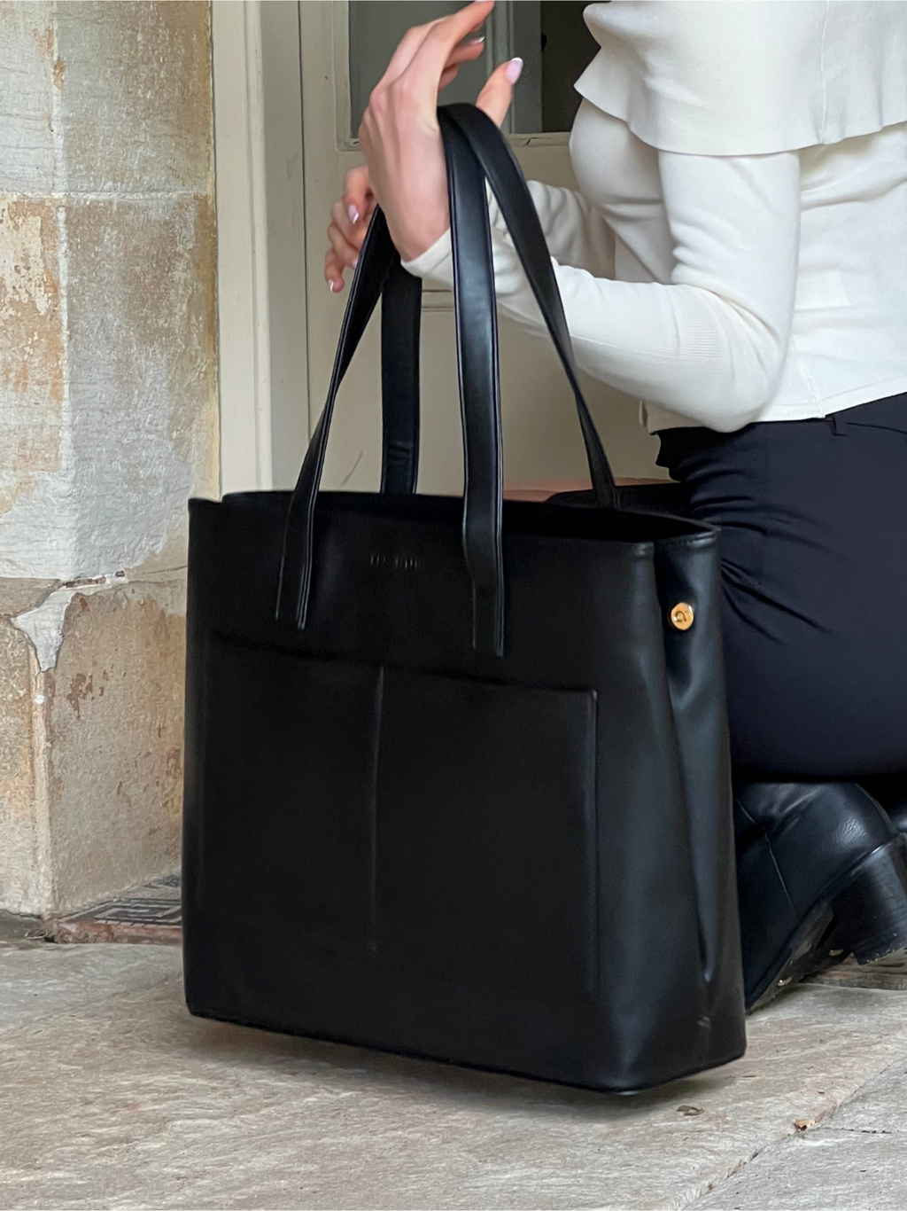 Minimalist vegan leather tote bag with laptop sleeve, designed for modern professionals.